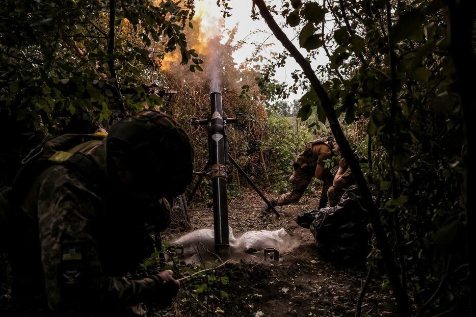 15日、ウクライナ東部ドネツク州で、ロシア側に向けて砲撃するウクライナ軍兵士（ロイター＝共同）