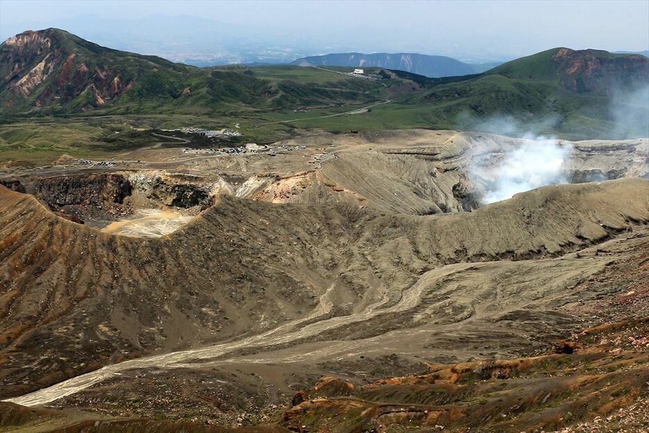 噴煙を上げる中岳第一火口と草千里ヶ浜、烏帽子岳（左）（写真＝池田浩伸）