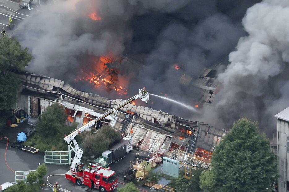 火災が発生した工場で消火活動する消防隊員ら＝10日午後6時47分、神奈川県寒川町（共同通信社ヘリから）