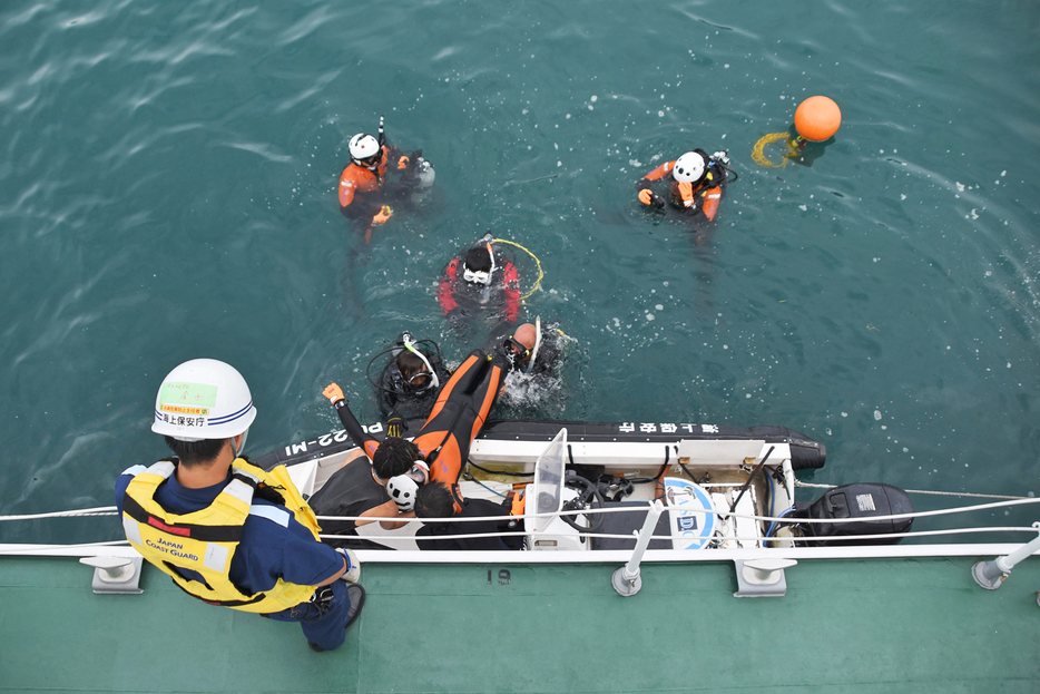 海底に沈んだ人をゴムボートに引き上げる訓練の様子＝13日、鹿児島県奄美市の名瀬港