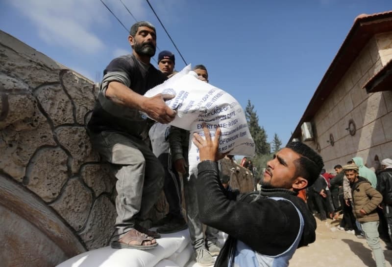 パレスチナ自治区ガザ中部デールバラハで、国連から支援物資の小麦の支給を受け取る人々＝２０２４年３月３日（ゲッティ＝共同）