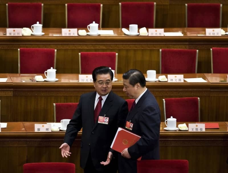 胡錦濤国家主席（左）に声を掛けられる習近平国家副主席（いずれも当時）＝２００９年３月、北京の人民大会堂
