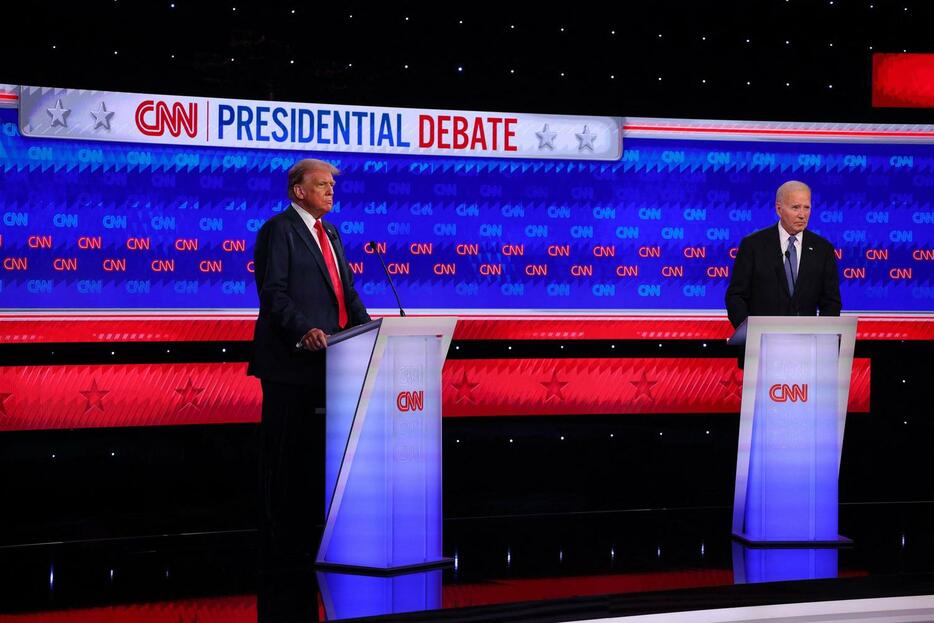 大統領討論会の開始時に演壇に立つ民主党候補のジョー・バイデン米大統領（右）と共和党候補のドナルド・トランプ前米大統領（ロイター）