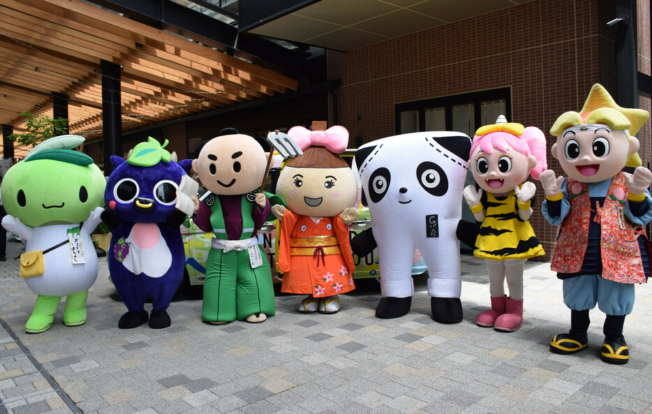 岡山・香川の名産品などをアピールするイベントが岡山市内で開催され、各地の自治体キャラクターが参加。家族連れが写真を撮影するなどして楽しんだ＝１５日