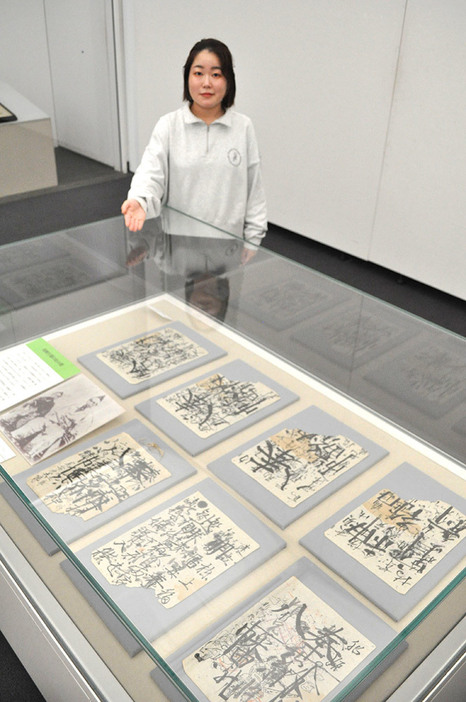 幼少期の尾崎が書いた字や落書きを紹介する眞壁さん＝相模原市立博物館