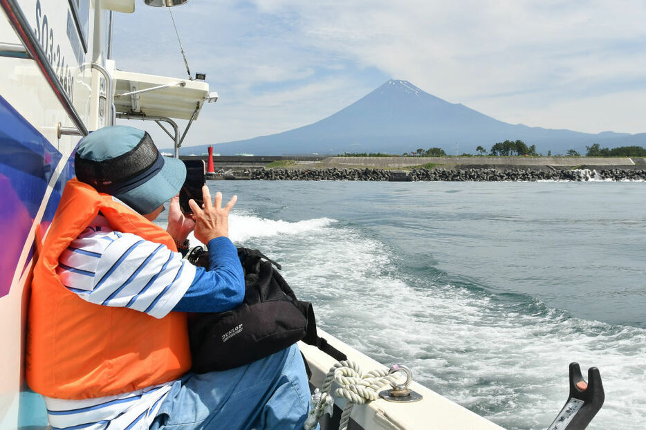 漁船から富士山を撮る乗船客＝田子の浦港沖
