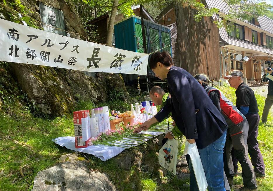 長衛の顕彰碑の前に花を手向ける参加者たち