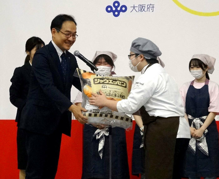 シャウエッセン1年分を贈呈する長田昌之氏㊧