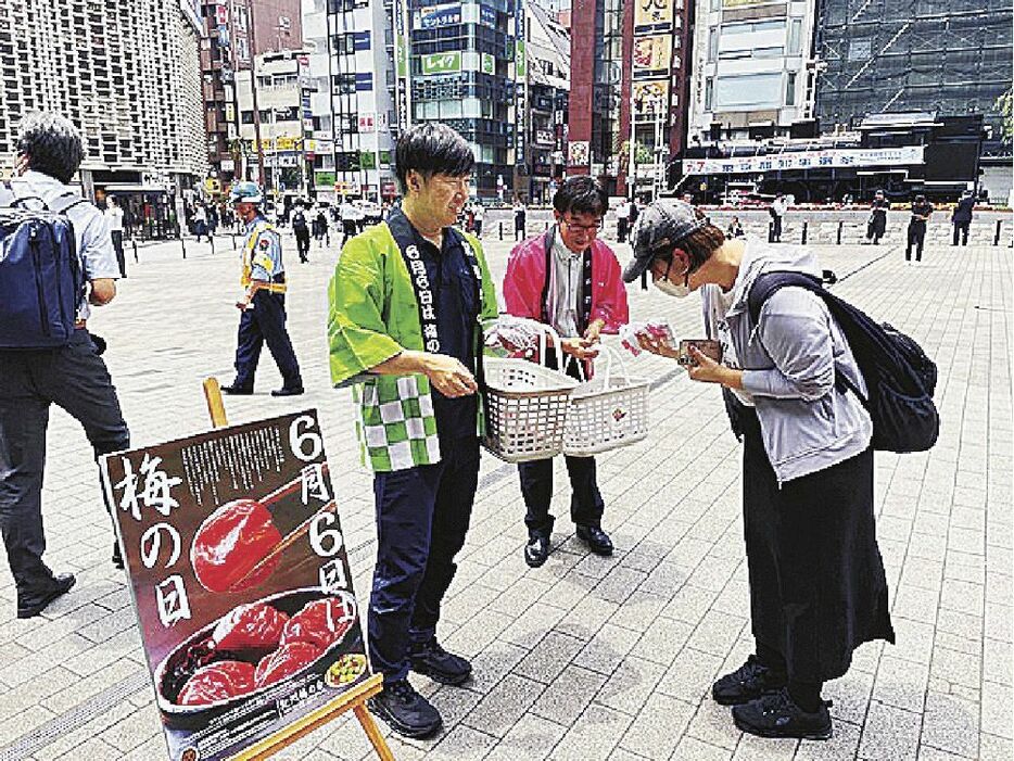 道行く人に梅干しセットを配布する若梅会のメンバーや関係者（６日、東京都で）＝紀州梅の会提供