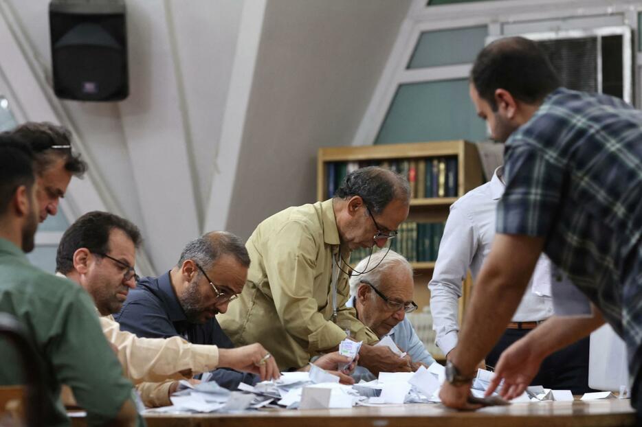 29日、イランの首都テヘランで大統領選の票を数える選挙スタッフ（ロイター＝共同）