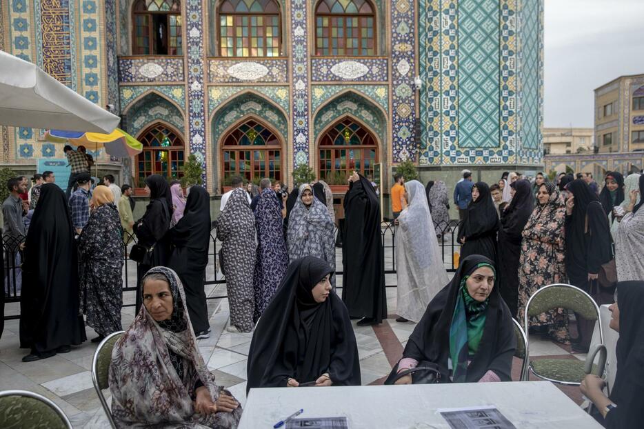 28日、イラン大統領選で投票に並ぶ女性たち＝テヘラン（ゲッティ＝共同）