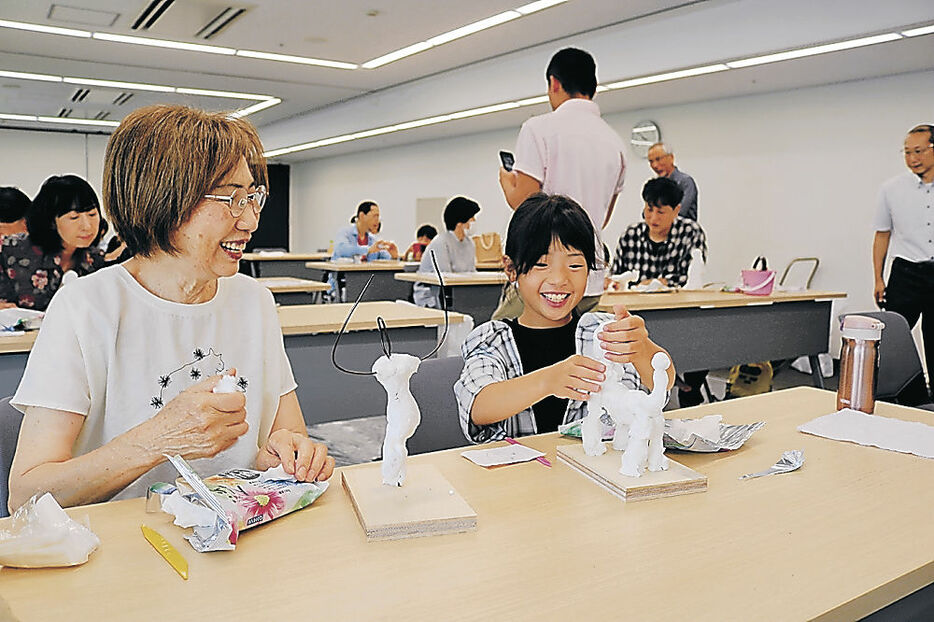 ワークショップで粘土を使った作品づくりを楽しむ参加者＝富山市の富山県民会館