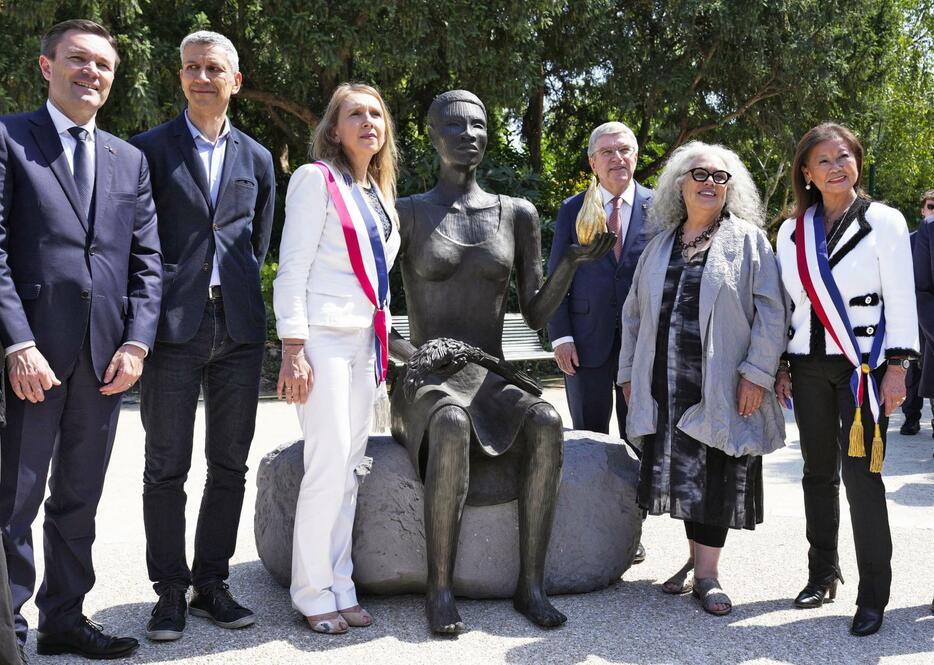 披露された「五輪彫刻」。右から3人目はIOCのバッハ会長＝23日、パリ（共同）