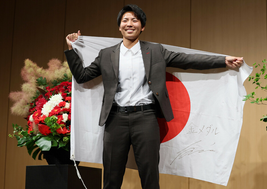 日本女子代表に選ばれ、目標を書いた国旗を手に撮影に応じる清家貴子＝１４日、東京都港区