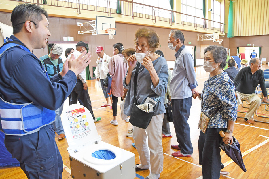 簡易トイレの説明を聞く参加者＝館山