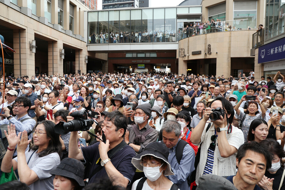 任期満了に伴う東京都知事選（７月７日投開票）は２２日、告示後初の週末を迎えた。各候補は都内各地を駆け巡り、自身の政策を有権者らに訴えた。写真は街頭演説を聞く人たち＝同日午後、東京都世田谷区