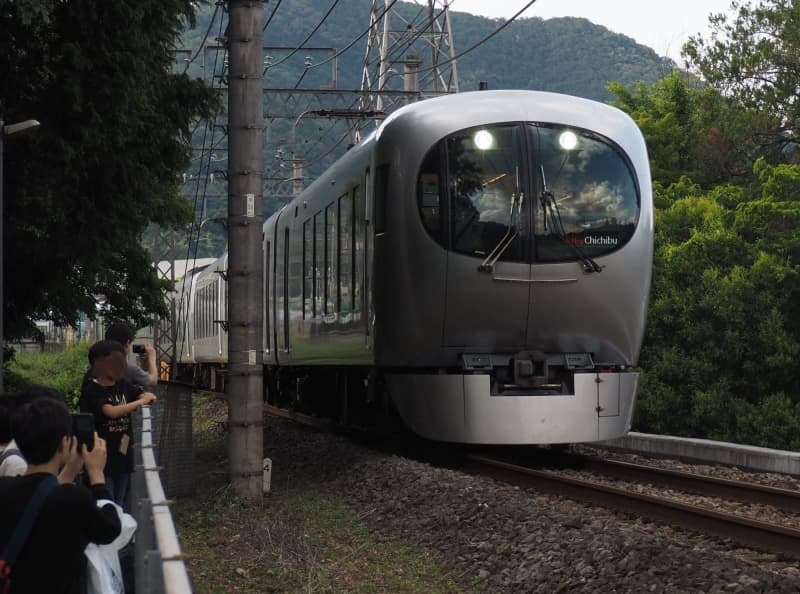 特急「ちちぶ」で走る「ラビュー」００１系と、撮影する人たち＝６月１日、埼玉県日高市