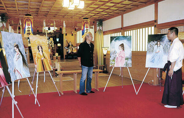 作品展示の準備を進める野田さん（中央）=中能登町二宮の天日陰比咩神社