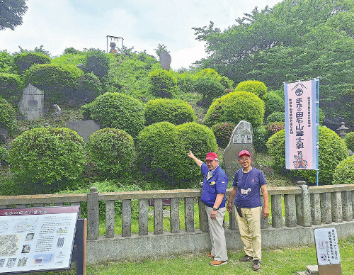 田子山富士塚を紹介する清水良介会長（左）（６日、志木市で）