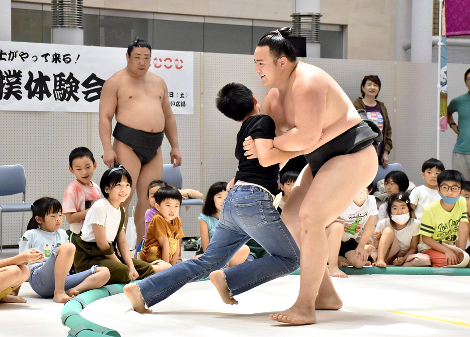 子どもたちと相撲対決を繰り広げる丹治（手前右）。左奥は若隆元 ＝15日、福島市・こむこむ