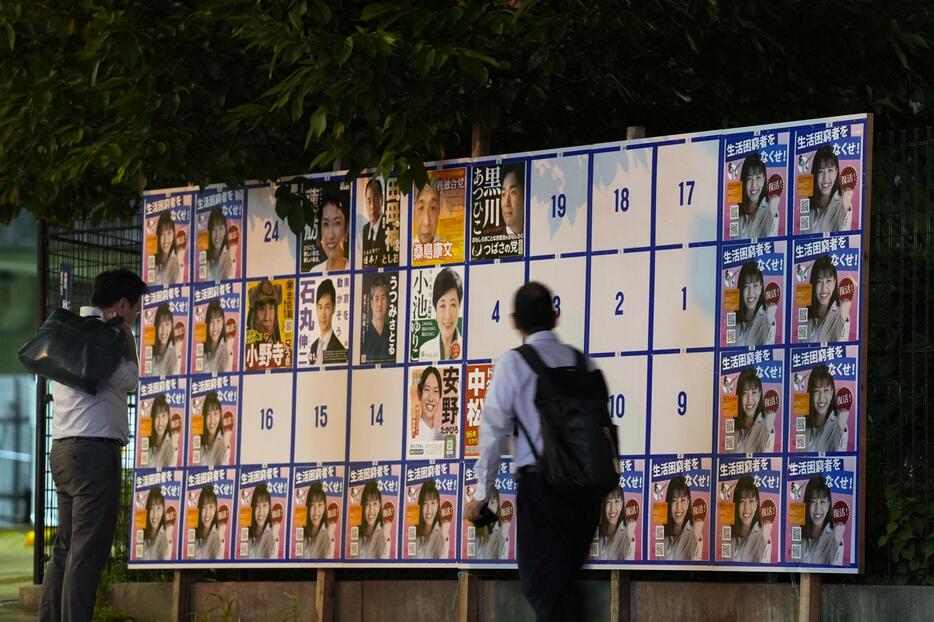 東京都知事選で、半分ほどの枠が同一のポスター（左右と下）で埋め尽くされた掲示板＝20日、東京都台東区
