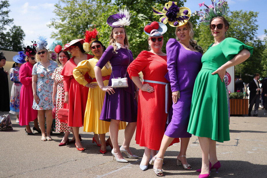 １８日、ロンドン郊外で色鮮やかなドレスに身を包み、華やかな帽子をかぶっているのは、英王室主催の競馬「ロイヤルアスコット」の観戦者たち。英競馬界で最も重要なレースとされ、社交の場でもある。