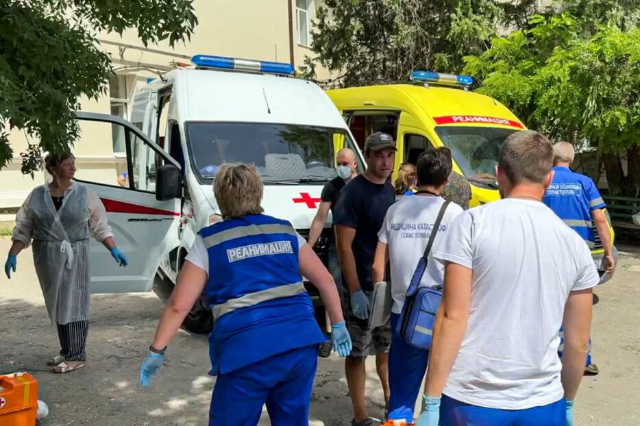 救急車の周囲に集まった人たち＝23日、ウクライナ南部クリミア半島セバストポリ（セバストポリ当局提供・タス＝共同）