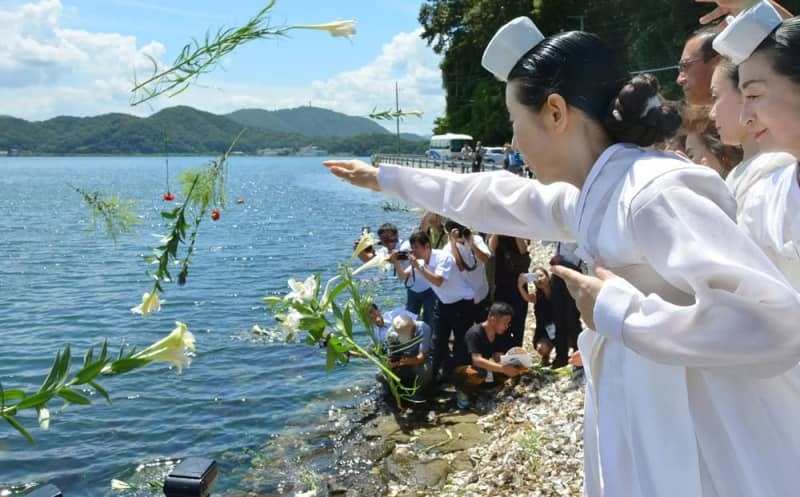 浮島丸事件から７０年となった２０１５年８月２４日、沈没現場の海に向かって花を投げ入れる女性たち＝京都府舞鶴市