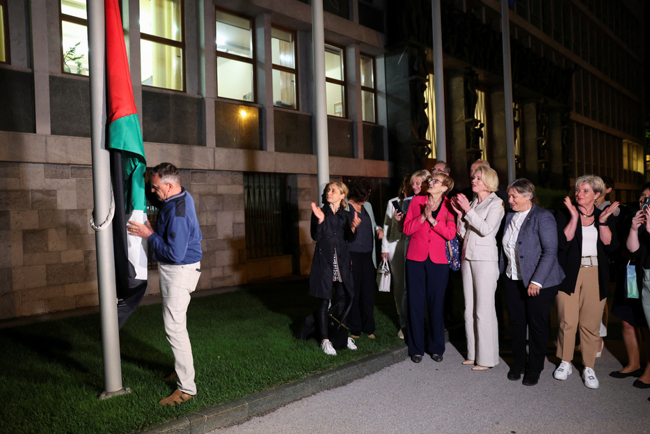 ６月４日、  スロベニアはパレスチナを正式に国家承認した。写真は同日、リュブリャナの議会前にパレスチナの旗を掲げる人々（２０２４年　ロイター/Borut Zivulovic）