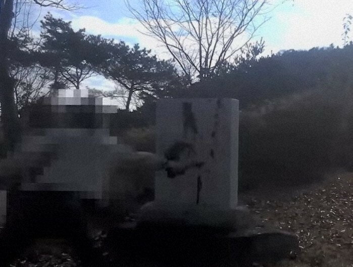 石碑のようなものに黒い液体をかける男性の映像。「新朝鮮」がユーチューブにアップした＝ユーチューブの動画より