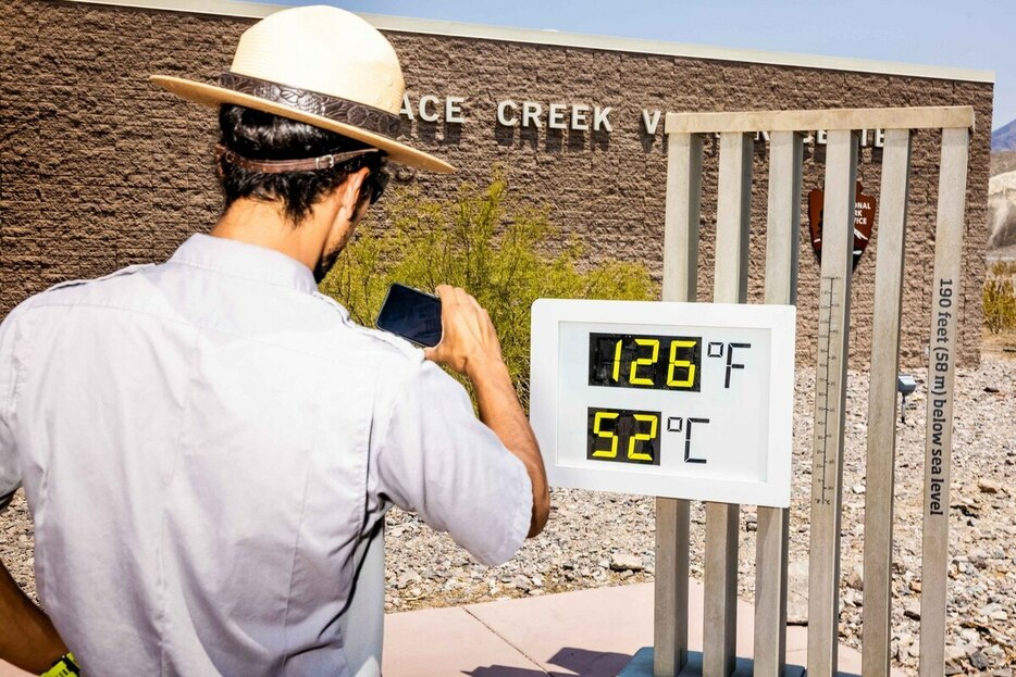 2021年、米カリフォルニア州のデスバレー国立公園で温度計の写真を撮る職員。1975年、メートル法は国が推奨する単位であると正式に宣言されたが、一般市民への普及はなかなか進まない。（PHOTOGRAPH BY ROGER KISBY, REDUX）