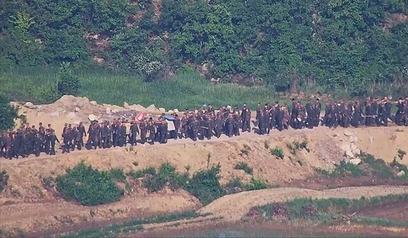 非武装地帯の作業に投入された北朝鮮軍兵士たちが作業道具を持って移動している=合同参謀本部提供