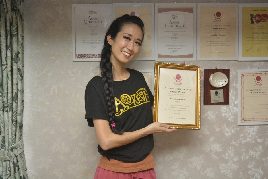 タヒチアンダンス大会で初優勝を飾り、賞状を手に笑顔を見せる天野佳子さん