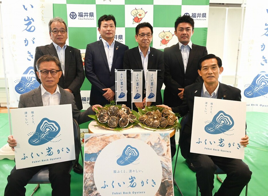 福井県産養殖イワガキの新ブランド「ふくい岩がき」のロゴマークを披露する中村副知事（前列左）ら＝6月4日、福井県の小浜市食文化館