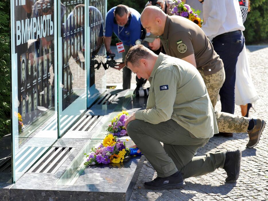 ウクライナの独立記念日の2023年8月24日には、ドニプロ市内の「記憶の小路」に住民らが集まり、祖国のために命をささげた人々に黙とうした。手前は花を手向ける市長（写真提供：ドニプロ市）