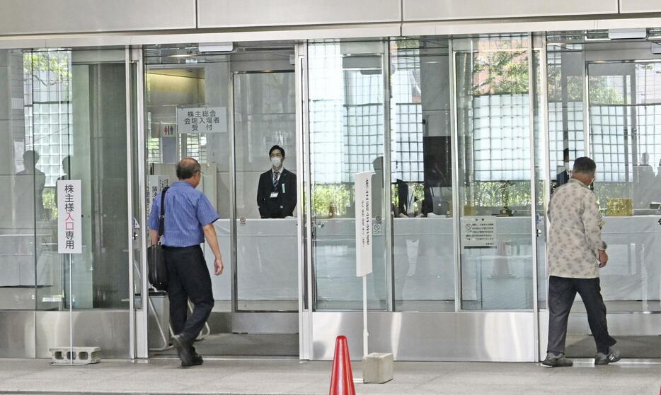 株主総会が開かれる北陸電力の本店に入る株主ら＝26日午前、富山市