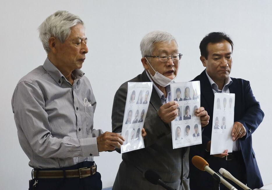第27代「高校生平和大使」に選ばれたメンバーの写真を手にする川野浩一さん（左）ら＝6日午前、長崎市役所