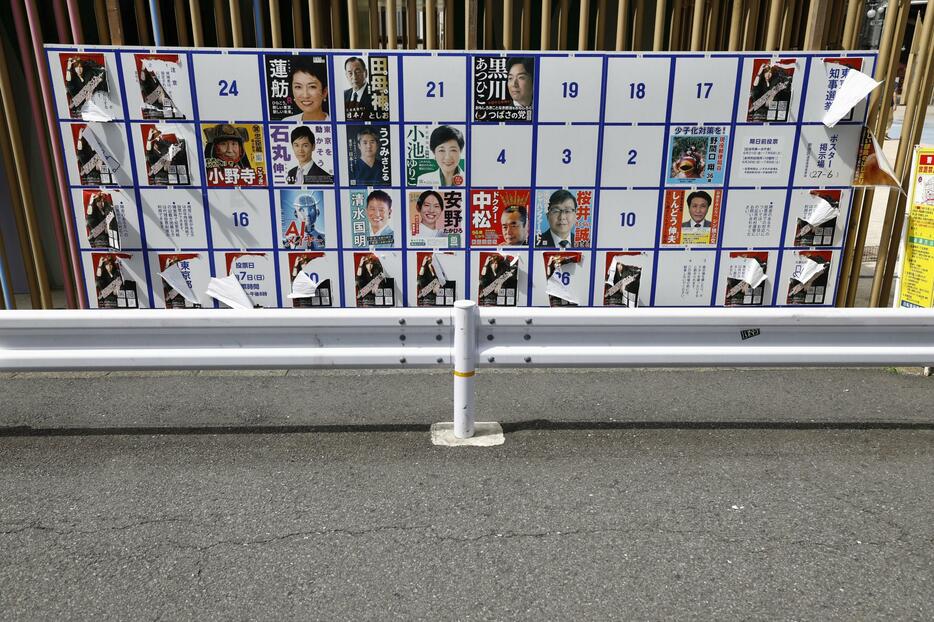 ポスターが破られた東京都知事選の掲示板＝24日午後、東京都新宿区