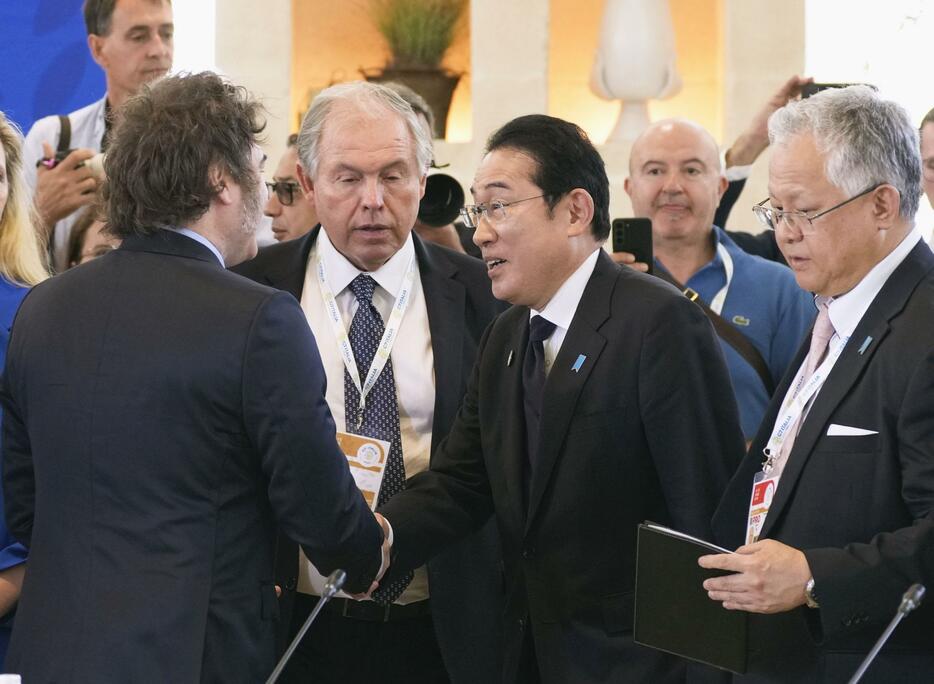 G7サミットの招待国を含めた拡大会合前に、アルゼンチンのミレイ大統領（手前左）と握手する岸田首相＝14日、イタリア南部プーリア州ファサーノ（共同）