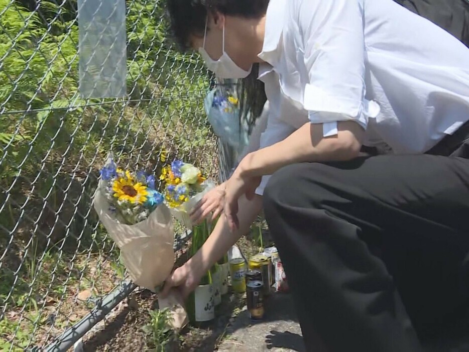 日野基本射撃場で花を手向ける人