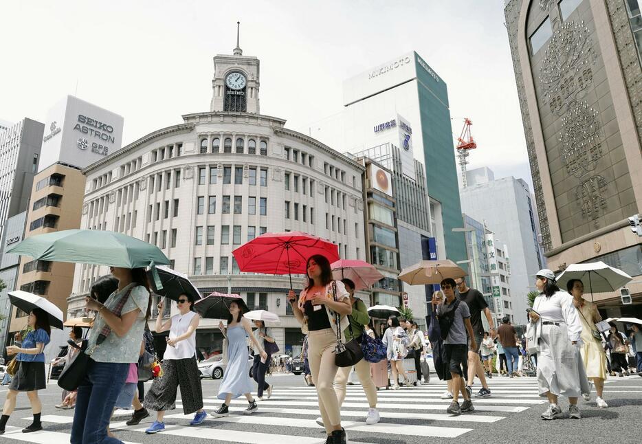 梅雨の晴れ間に気温が上昇した東京・銀座を行き交う人たち＝24日午後
