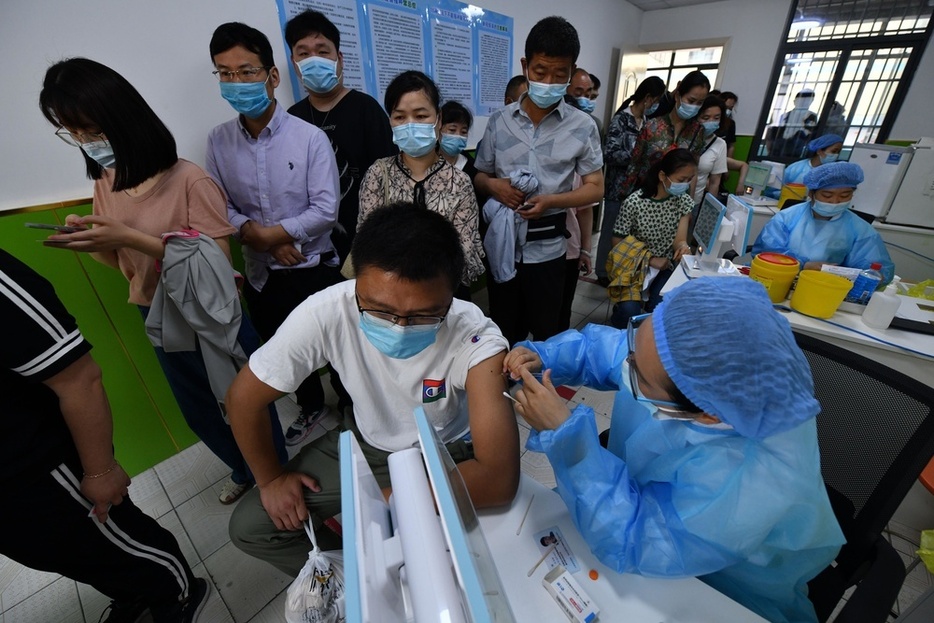 中国安徽省で新型コロナウイルスのワクチンを投与する医療従事者（右）＝2021年（ゲッティ＝共同）