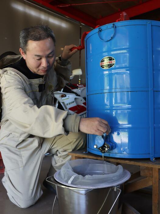 専用機具を使って蜜を搾り取る荻野さん＝兵庫県丹波市市島町白毫寺で