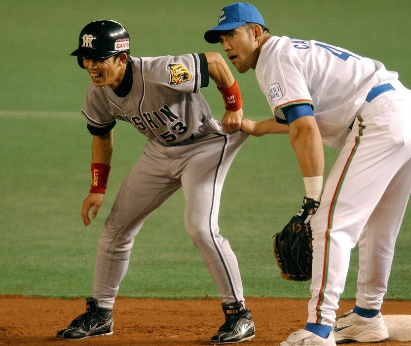 2003年のオールスターで、盗塁をさせまいと西武・カブレラにユニフォームを引っ張られる阪神・赤星の