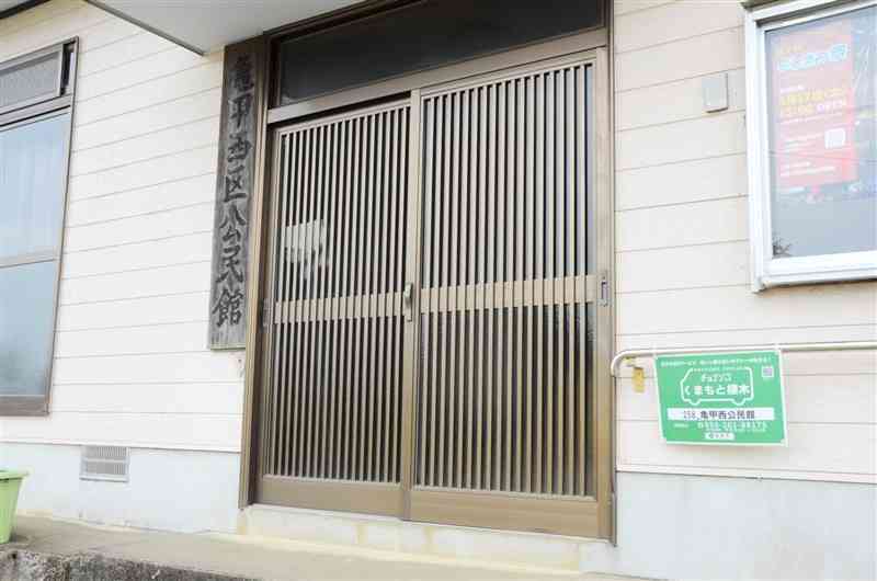 亀甲西区公民館に設置されている「AIデマンドタクシー」の停留所の目印（右下）＝19日、熊本市北区