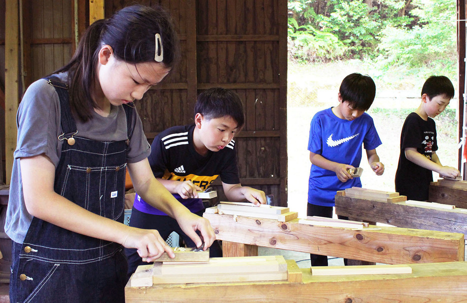 箸作り体験で、一生懸命かんな掛けをする宮川小の6年生たち ＝大台町唐櫃の宮川森林組合唐櫃作業場で