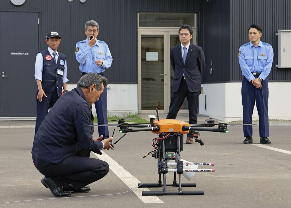 ドローンを使って住民に避難を呼びかける訓練を行う北海道警名寄署の米村和信署長（奥左から2人目）＝4日午後、北海道名寄市