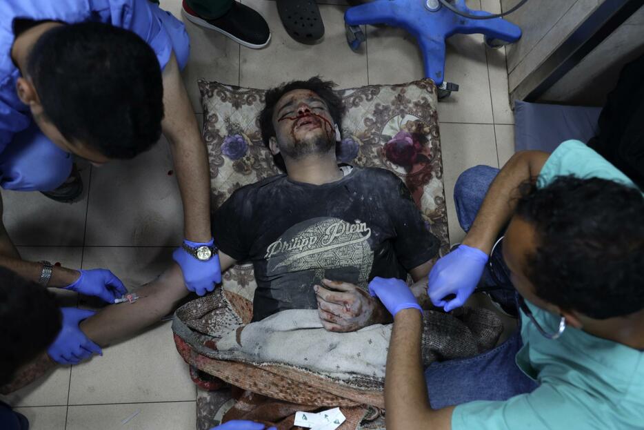 パレスチナ自治区ガザ中部デールバラハの病院で、負傷者を治療する医療関係者＝10日（AP＝共同）
