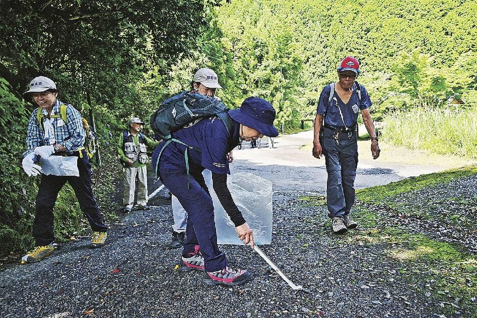 熊野古道を歩きながらごみを拾う清掃ウオークの参加者（和歌山県田辺市本宮町で）