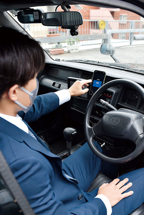 ライドシェアの運行テストで、配車アプリを操作するつばめタクシーの上滝幸平さん＝5月31日午後、さいたま市浦和区